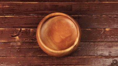 Kahve çekirdekleri ahşap plaka kahverengi ahşap masa üzerinde büyük bir ahşap kase içinde dökme