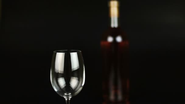 Garrafa e copo de vinho sobre fundo preto — Vídeo de Stock