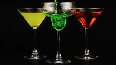 Yeşil kokteyl bardağı içinde dökme. Farklı kokteyller kenar siyah arka plan üzerine üç bardak
