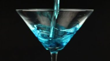 Martini cam siyah zemin üzerine mavi kokteyl dökme