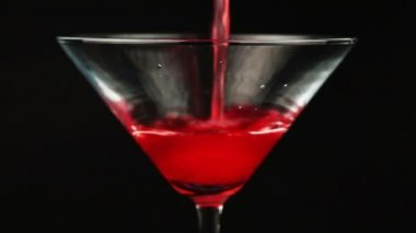 Martini cam siyah zemin üzerine kırmızı kokteyl dökme