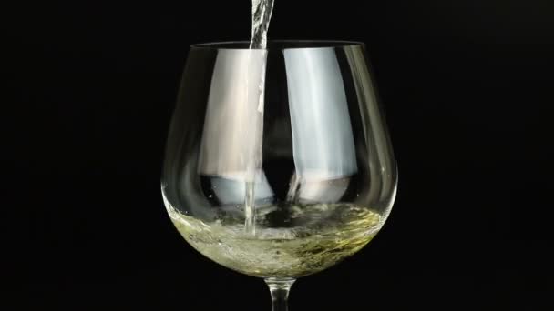 Vin blanc versant dans le verre sur fond noir — Video