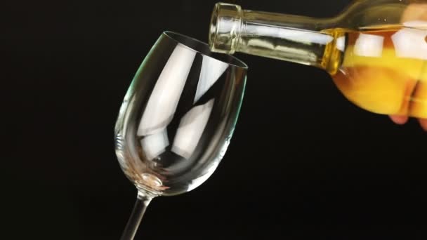 White wine pouring into glass on black background — Stock Video