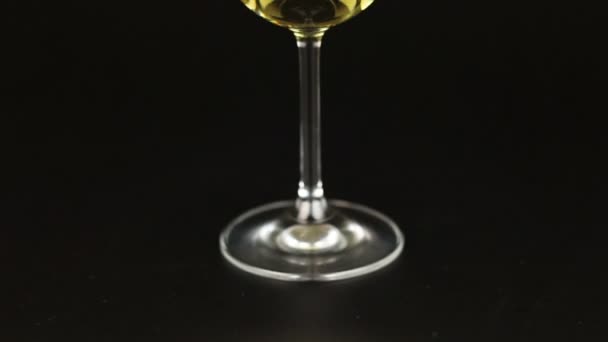 Vinho branco em vidro sobre fundo preto — Vídeo de Stock