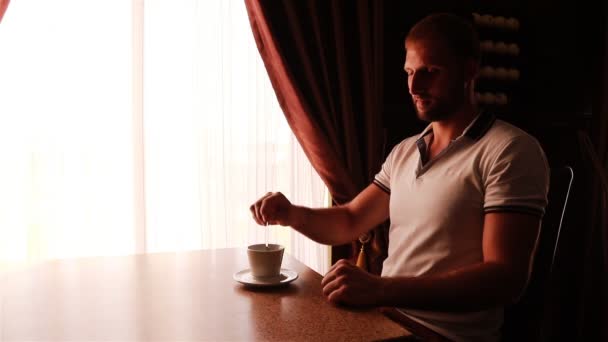 Μοντέρνα ελκυστική νεαρός πίνοντας τον καφέ στην καφετέρια — Αρχείο Βίντεο