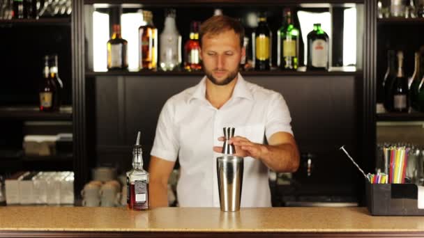 Barman pouring contents of jigger and pours in shaker prepares alcoholic cocktail — Stock Video