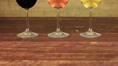 Beyaz şarap, gül şarap ve kırmızı ahşap masa üzerinde şarap