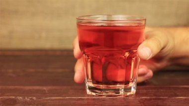 Ahududu suyu, roselle suyu, üzüm suyu üzerinde ahşap masa içme genç adam