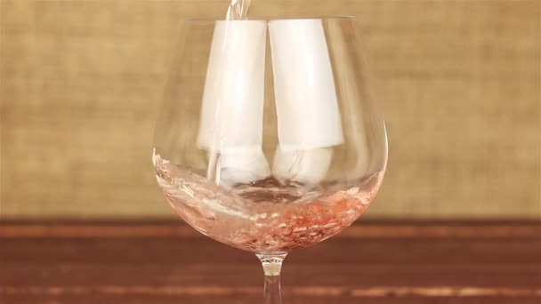 Vin rose versé dans du verre sur une table en bois — Video