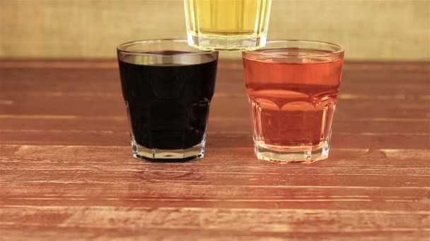 Granatapfelsaft, Himbeersaft und Traubensaft auf Holztisch — Stockvideo