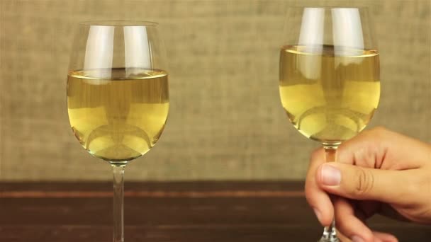 Junger Mann trinkt Weißwein auf Holztisch — Stockvideo