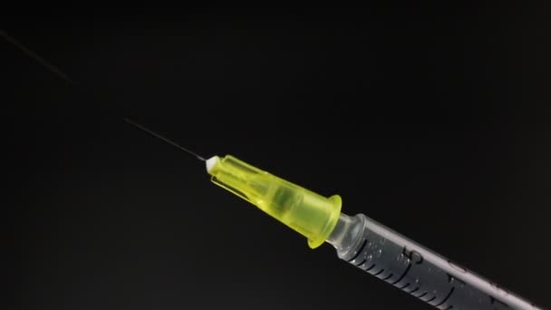 Sproeien van de geneeskunde van de spuit vóór injectie op zwarte achtergrond — Stockvideo