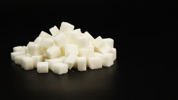 Spuiten van insuline aanbrengend stapel suiker naast suikerklontjes, diabetes concept op zwarte achtergrond — Stockvideo