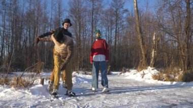Eski giysiler içindeki genç arkadaşlar kışın donmuş bir gölde paten kaymayı öğrenirler.