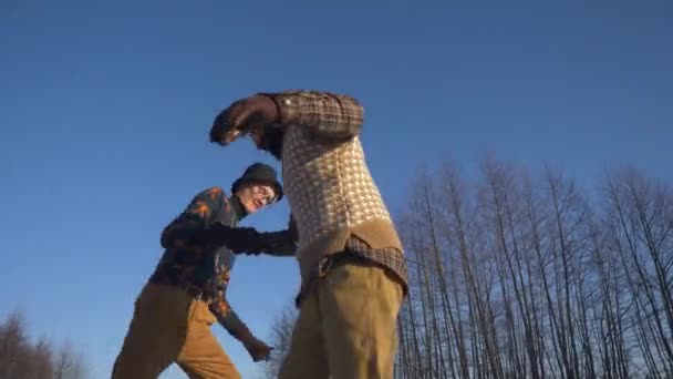 Deux garçons indiens et européens apprennent à patiner sur un lac gelé et à jouer au malin. — Video