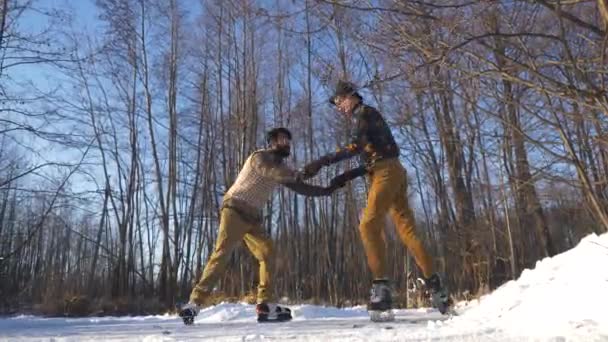 Dois meninos indianos e europeus aprendem a patinar em um lago congelado e jogar travessura. — Vídeo de Stock