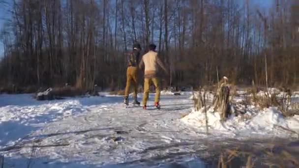 Dos chicos indios y europeos aprenden a patinar en un lago congelado y a hacer travesuras. — Vídeos de Stock