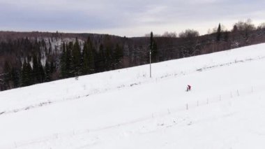 Kayak okulu. Eğitmen çocuğa kayak yapmayı öğretir. Hava görünümü
