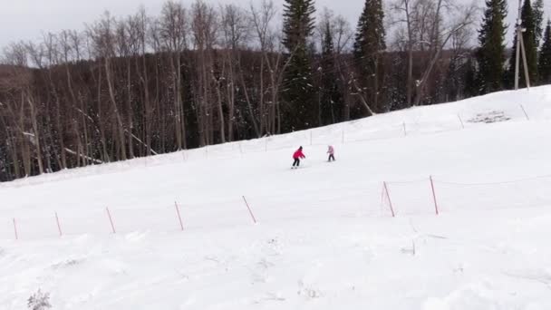 Skidskola. Läraren lär barnet att åka skidor. Indikerar rörelseriktningen med pinnarna. — Stockvideo