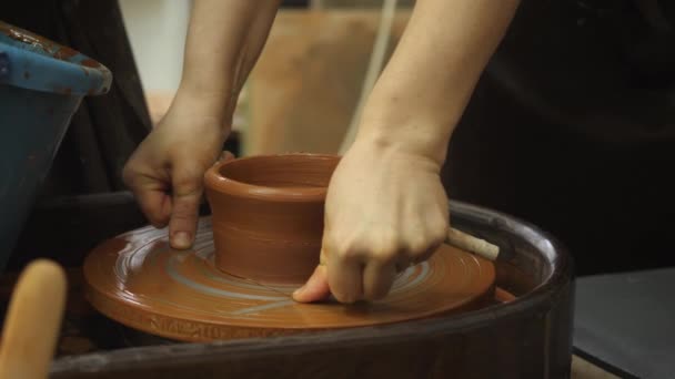 The potter removes the blank from the potters wheel with a thin fishing line. — Stock Video
