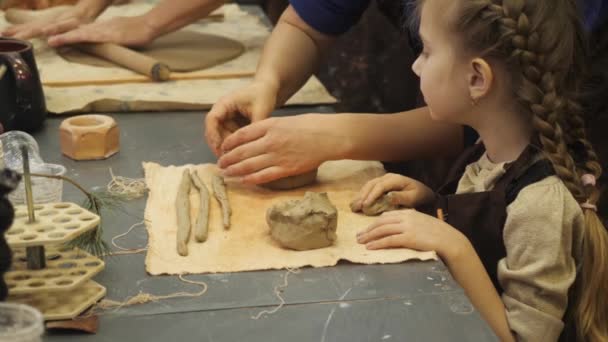 A skilled potter, he teaches his young daughter how to make a vase. — Stock Video