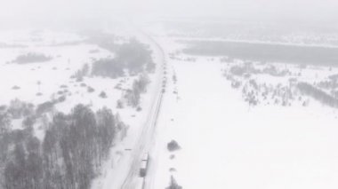Karla kaplı bir otoyolda kamyonlar trafikte sıkıştı..