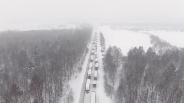 Los camiones están atascados en el tráfico en una carretera cubierta de nieve. — Vídeo de stock