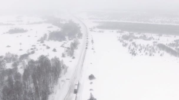Lastbilar är fast i trafiken på en snötäckt motorväg. — Stockvideo