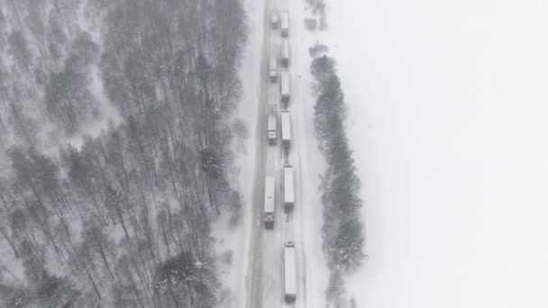 Los camiones están atascados en el tráfico en una carretera cubierta de nieve. — Vídeo de stock