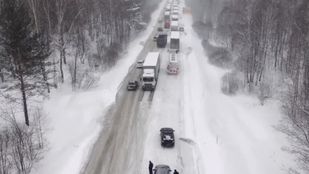 Lastwagen stehen auf verschneiter Autobahn im Stau. — Stockvideo