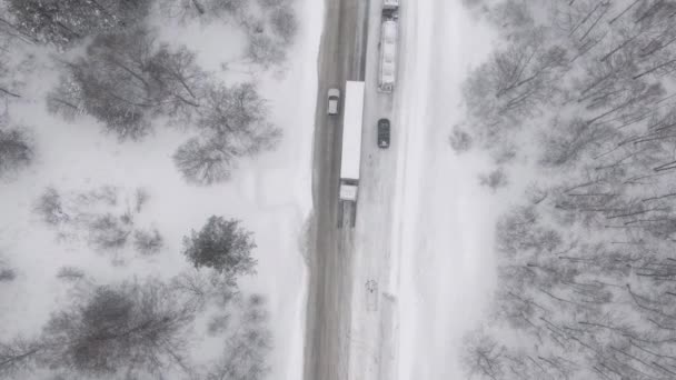 Náklaďák klouže, snaží se vylézt na sněhovou cestu do kopce během sněhové bouře. — Stock video