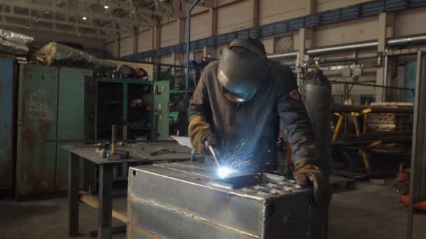 Кузнечный сварщик в защитной маске работает с металлом с помощью сварочной машины — стоковое видео