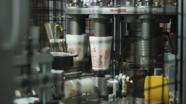 Sıcak içecek için yakın çekim için kağıt bardak üretimi. Fabrika hattının otomatik taşıma bandında ticari seri üretim. Fast food işi için ekoloji malzemeleri kullanan yüksek teknoloji makine fabrikası.