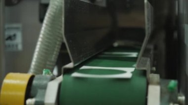 Kağıt kırıntılarını, parçaları, üretim atıklarını, fabrikadaki, fabrikadaki, fabrikadaki, fabrikadaki, fabrikadaki, sergilenen kağıt bardak yapma makinesinin bir parçasını kaldırmak için taşıma bandı. Kapatın. Sanayi, ekipman, teknoloji, üretim kavramı