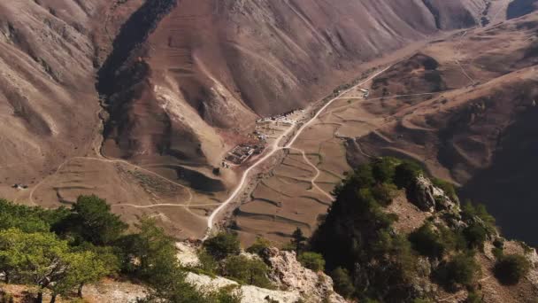 Uitzicht vanuit de lucht op de bergweg in de kloof. Landschap van de noordelijke Kaukasus. Stockvideo