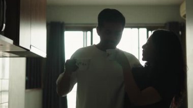 Young romantic couple enjoying their morning coffee together in the kitchen at home