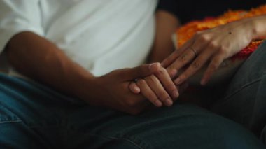 Close up of a man and a woman holding hands, showing affection, comfort, and emotional support