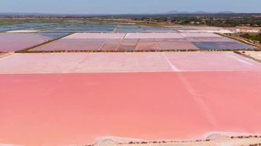 Aerial shot revealing vibrant salt evaporation ponds near es trenc shoreline