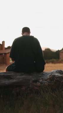 Sakin erkek, sakin günbatımının keyfini çıkarıyor. Geniş kırsal manzaraya karşı silueti var.