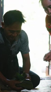 Güneydoğu Asyalı çift geleneksel teknikleri kullanarak geleneksel yemekleri köy evinde hazırlıyor: FullHD Dikey