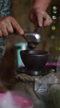 Asya kabilesinde lahu geleneksel bir şekilde çıplak ayakla pişirilir ahşap havan ve havan mermisiyle kırsal bir mutfakta taze bitkiler öğüterek - FullHD