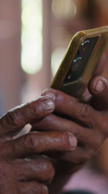 Asyalı üst düzey bir adamın dijital ortamda dijital ortamda sörf yapan akıllı bir telefonla etkileşime giren kirli elleri - FullHD dikey