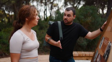 Faaliyet yapan iki kişi, erkek doğadaki bir kadınla bir yönetim kurulunda bilgi tartışıyor.