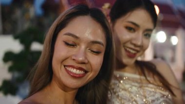 İki güzel genç kadın Tayland 'daki Loy Krathong Festivali' nde selfie çekiyorlar.