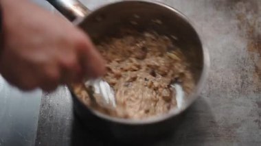 Profesyonel şef mantar ve tereyağlı İtalyan risottosunu hazırlayıp karıştırıyor - 4K yatay