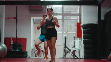 İki motive olmuş kadın spor salonunda tekmeleyip yumrukluyor.