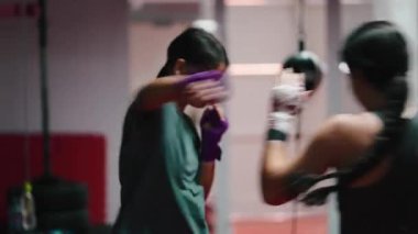 Spor salonunda antrenman yaparken boks teknikleri ve idman yapan iki genç kadın - 4K yatay