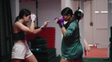 Dövüş sırasında boks ve kickboks teknikleri uygulayan iki genç kadın - 4K yatay oturum