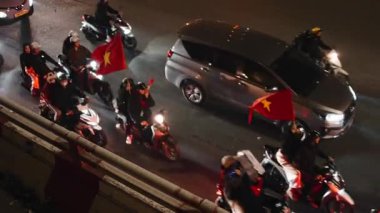 Motosikletli Vietnamlı büyük bir hayran kitlesi sokakta bayraklarla futbol zaferini kutluyor - 4K yatay