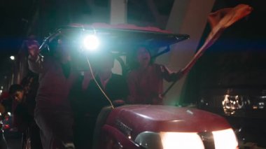 Hevesli Vietnamlı hayranlar gece bir traktörde futbol zaferini kutluyorlar, ellerinde bir bayrak sallıyorlar - 4K yatay